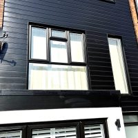 New black PVC cladding installation around black framed windows