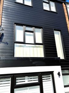 New black PVC cladding installation around black framed windows