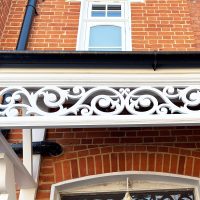 Detail of finials of white double door canopy installation