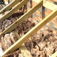 New door canopy insulation being installed before roof