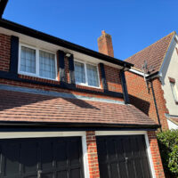 Repainted black garage doors and mock Tudor beams on the front of the house.