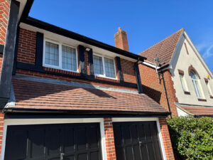 Repainted black garage doors and mock Tudor beams on the front of the house.